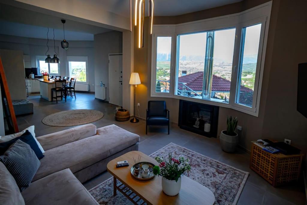 - un salon avec un canapé et une grande fenêtre dans l'établissement The Urban Escape, à Ioannina