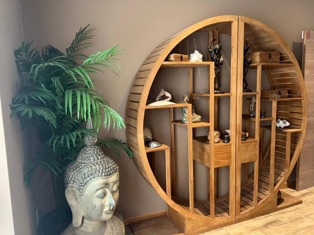 een kamer met een houten plank met een standbeeld en een plant bij zen atitude in Sint-Martens-Lennik