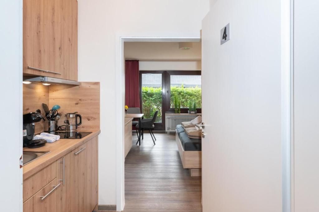 a kitchen with wooden cabinets and a living room at Quartier vier in Büsum