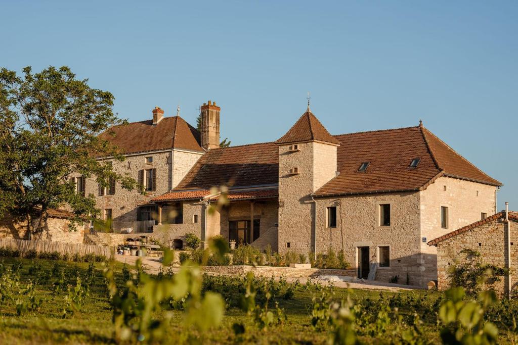 un gran edificio de piedra con un patio delante en Clos des Dames de Lancharre - La Maison Des Vignes, en Chapaize