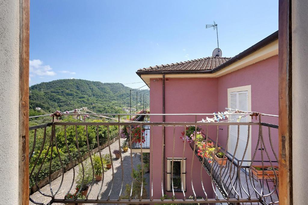 Una casa rosa con un balcón con flores. en La Torre, en Arcola