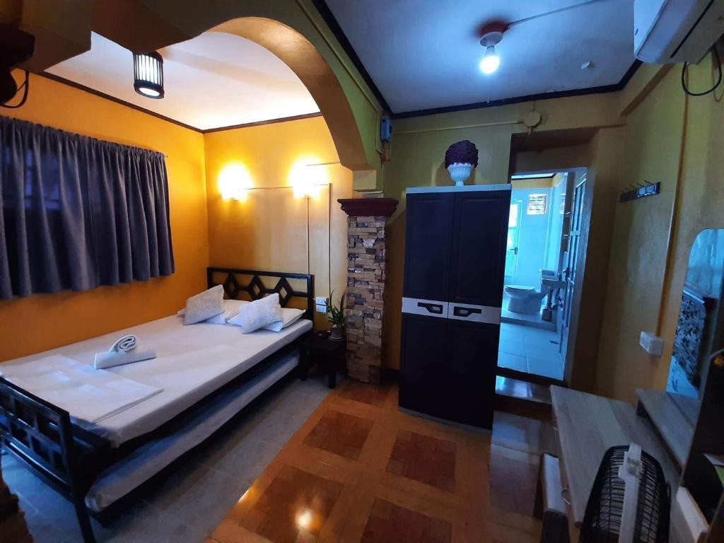 um pequeno quarto com uma cama e um frigorífico em CARRIBEAN1 TRANSIENT HOUSE em Lucap