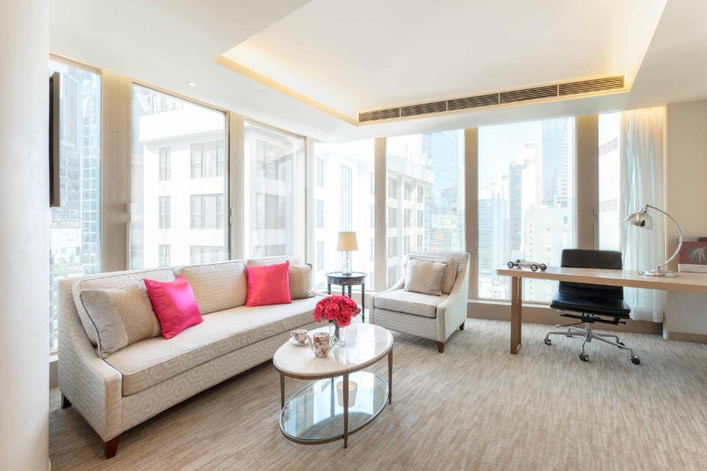 salon z kanapą i biurkiem w obiekcie The Pottinger Hong Kong w Hongkongu
