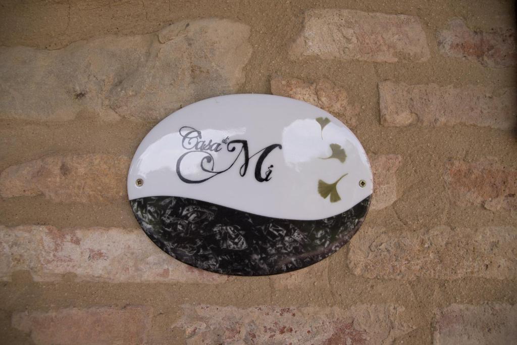 eine Platte, die an einer Ziegelmauer hängt in der Unterkunft Casa Di Mi in Serrungarina