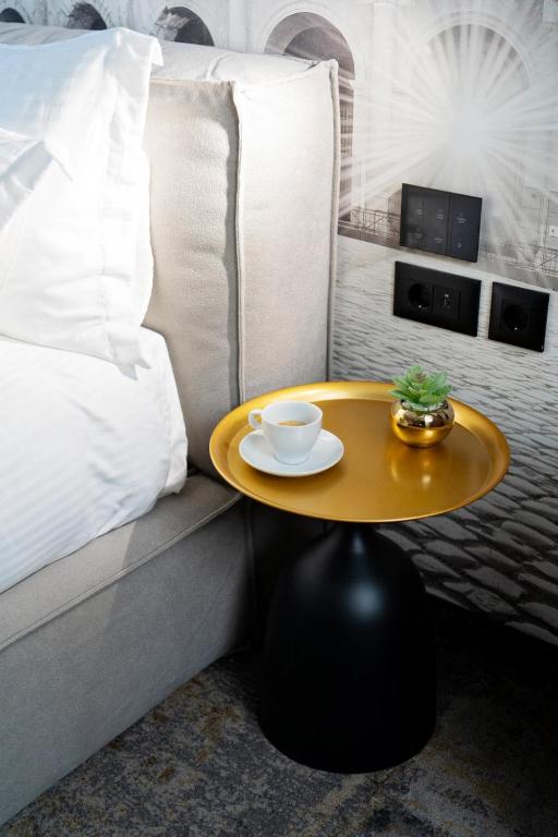 a coffee table sitting next to a couch with a bed at MM Boutique Hotel in Burgas