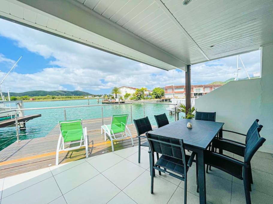 una terraza con mesa y sillas en un barco en Villa 238A Jolly Harbour en Jolly Harbour