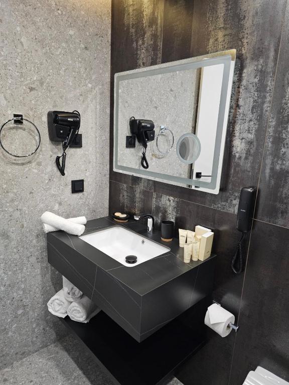 a bathroom with a sink and a mirror at MM Boutique Hotel in Burgas