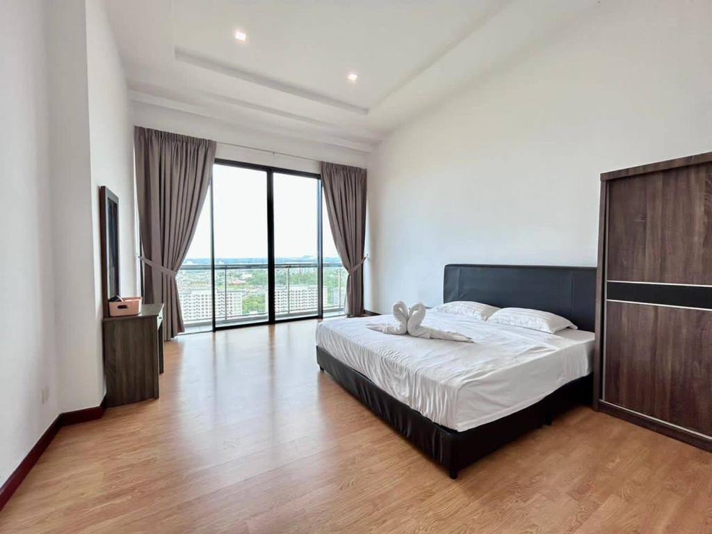 ein Schlafzimmer mit einem Bett und einem großen Fenster in der Unterkunft Jeff and Ricky Homestay16-Boulevard Imperial Suite in Kuching
