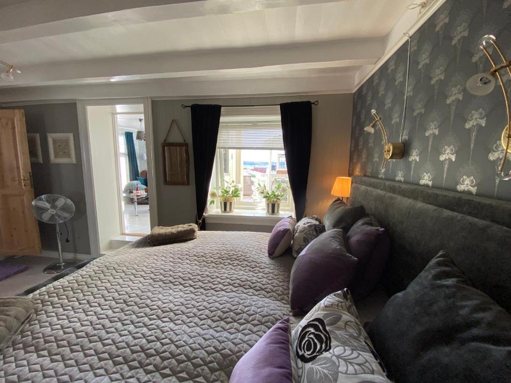 克拉格勒的住宿－Monas sommerresidens midt i hjertet av Kragerø，一间卧室设有一张大床和一个窗户。