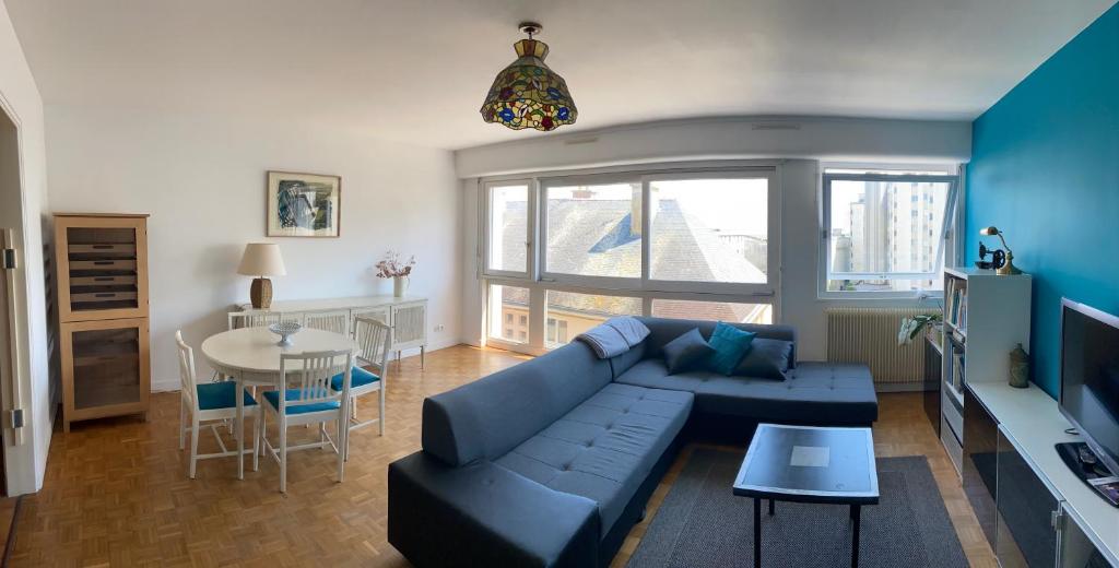 un salon avec un canapé bleu et une table dans l'établissement Appartement de ville et plage, à Concarneau