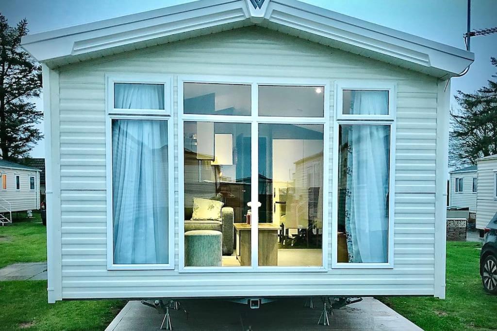 uma casa branca com uma janela num quintal em Seaview Retreat unavailabl3 em Mainsriddle