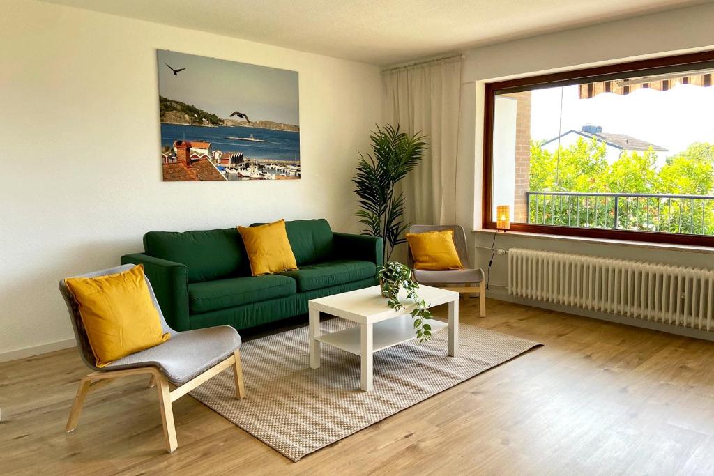 uma sala de estar com um sofá verde e uma mesa em Beautiful house in Hilden em Hilden