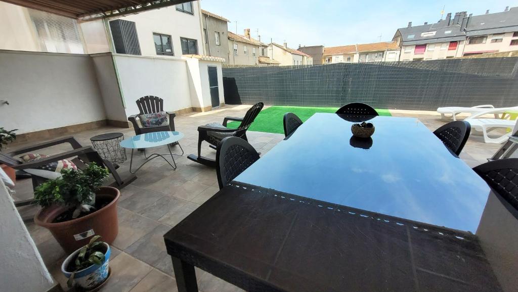 een patio met een tafel en stoelen op een balkon bij El Hogar de Todos in Ourense