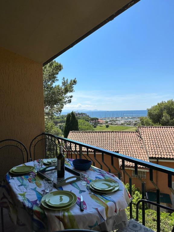 una mesa con una botella de vino en el balcón en Appartamenti Portiglioni-Belvedere, en Puntone di Scarlino