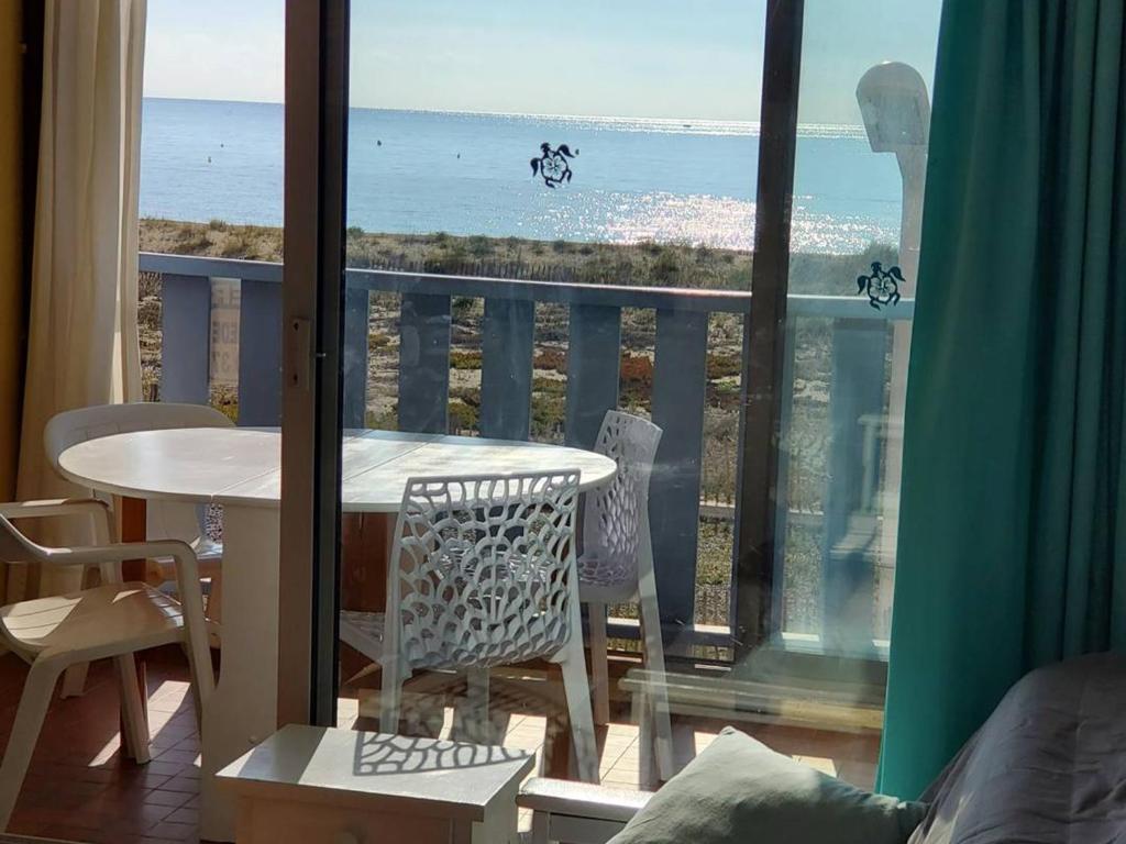 un balcon avec une table et des chaises et une vue sur l'océan dans l'établissement Appartement en bord de mer pour 4 pers., parking privé, proche commerces, plage sans route à traverser - FR-1-81-374, à Port-Leucate