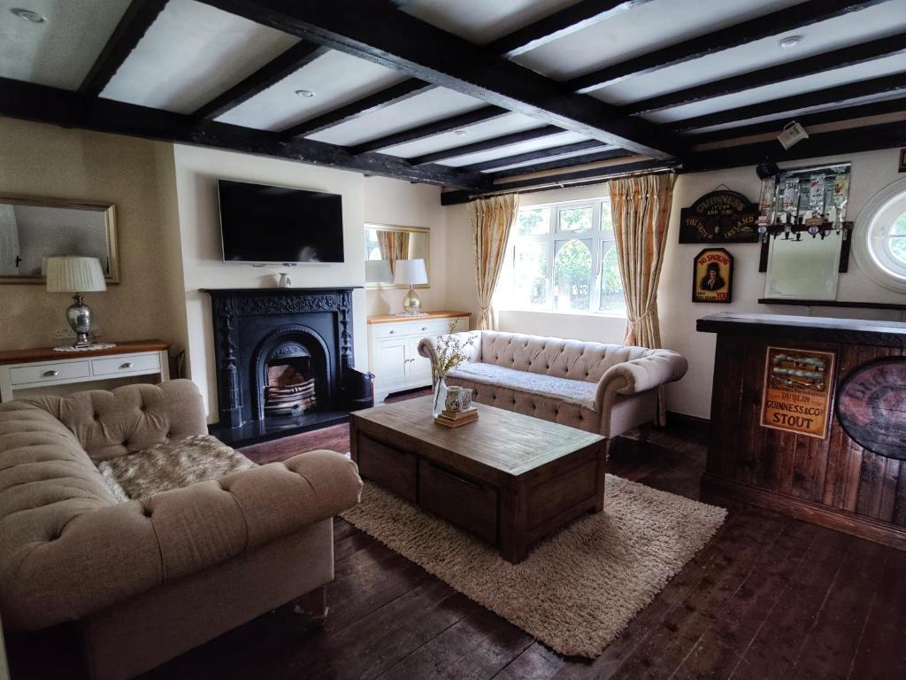 a living room with two couches and a fireplace at Rooms at Ballysax House in The Curragh