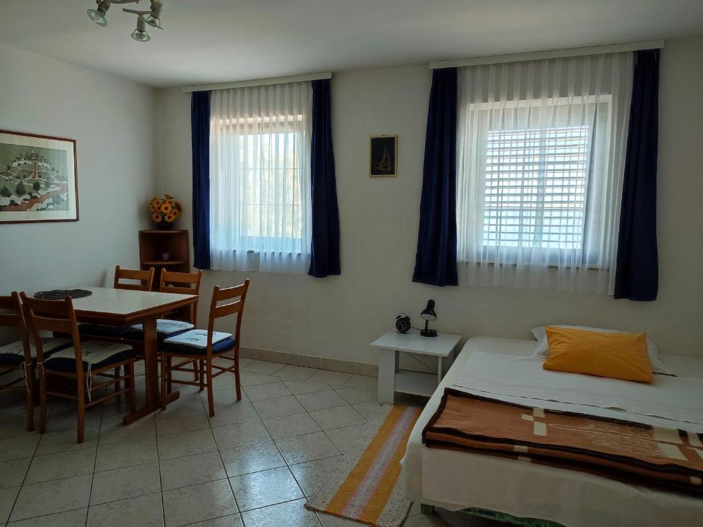 sypialnia ze stołem i łóżkiem oraz jadalnią w obiekcie Apartmani Ela w Bibinje