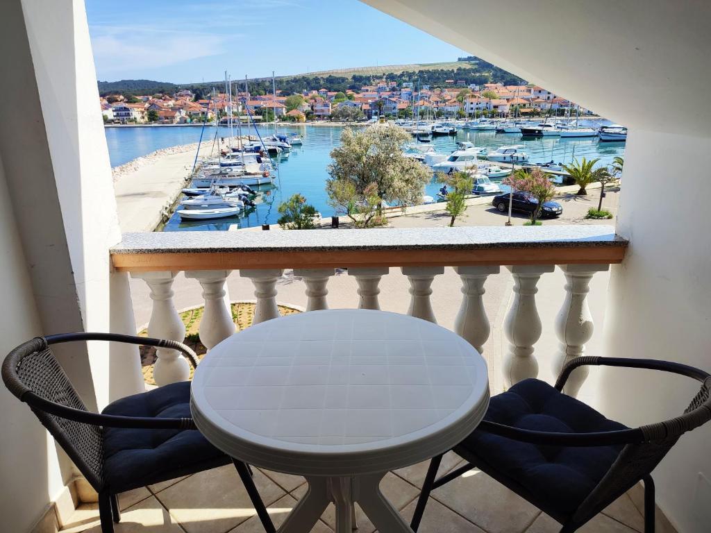 stół i krzesła na balkonie z widokiem na port w obiekcie Apartmani Ela w Bibinje