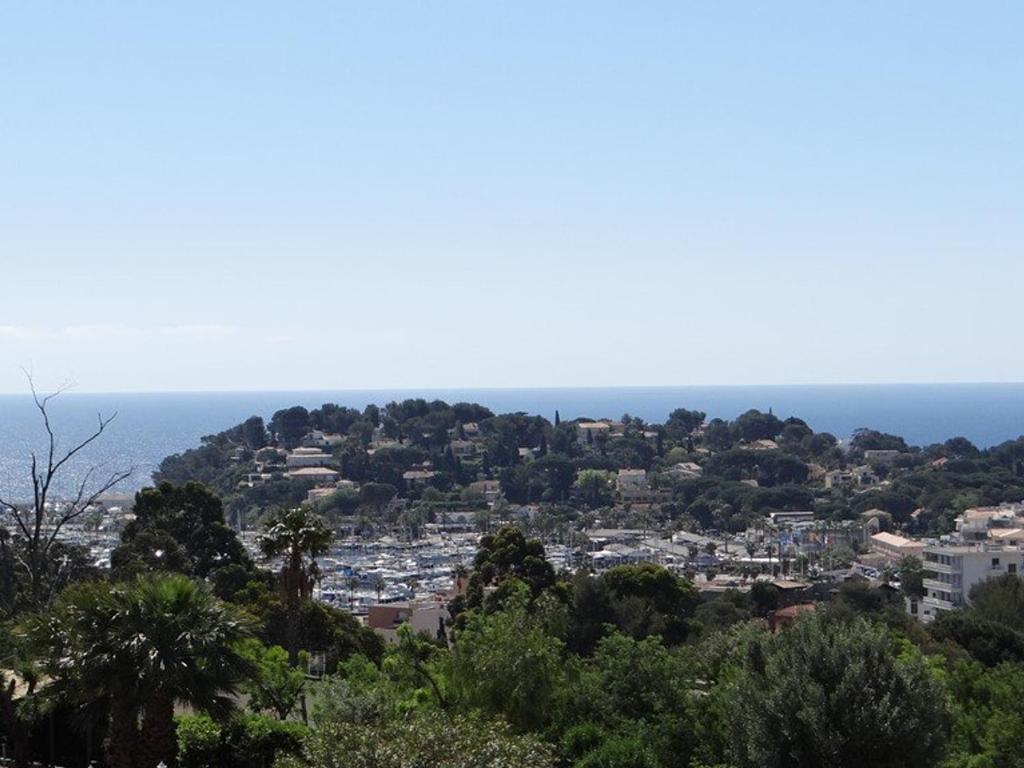 Vue sur une ville avec l'océan en arrière-plan dans l'établissement Charmant appartement climatisé, parking, animaux admis - FR-1-100-221, à Cavalaire-sur-Mer