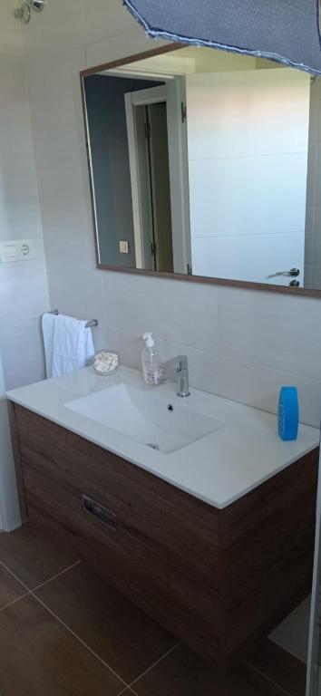 łazienka z umywalką i dużym lustrem w obiekcie Apartamentos M° Esther w mieście A Lanzada