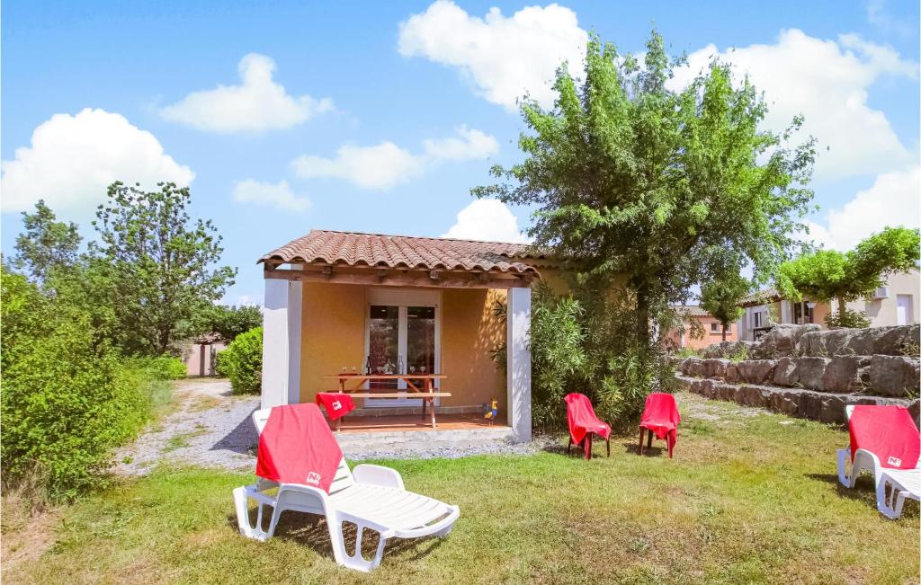 a group of red chairs in front of a house at Amazing Home In Grospierres With Outdoor Swimming Pool, Wifi And 2 Bedrooms in Grospierres