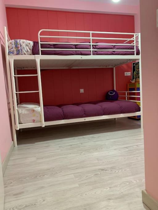 two bunk beds in a room with purple sheets at Apartamento Alicante San Juan playa 1ª línea in Benimagrell