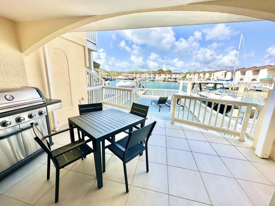 patio con mesa y sillas en el balcón en Sunshine Villa en Jolly Harbour