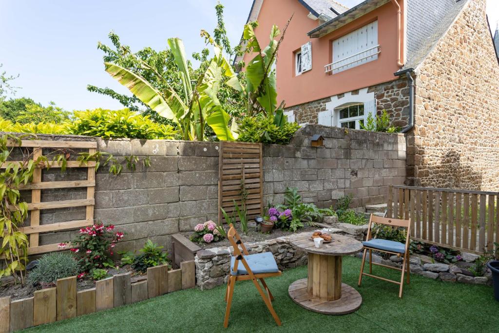 Ti Massa - Petit cocon avec jardin à St Servan في سان مالو: حديقة صغيرة بها طاولة وكراسي أمام المنزل