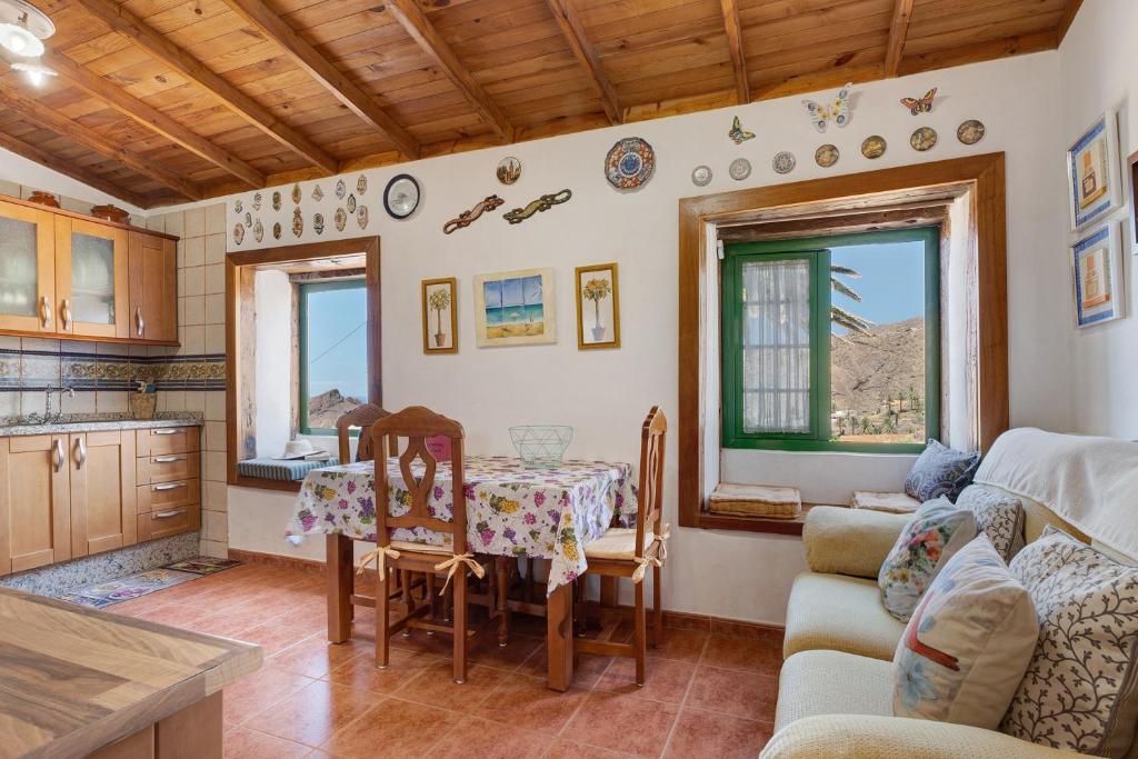a kitchen and dining room with a table and chairs at Rosa del Negro in Alojera
