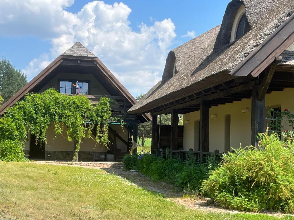 ein Haus mit einem Schiebedach und einem Hof in der Unterkunft Dom na Krańcu Świata in Łapicze