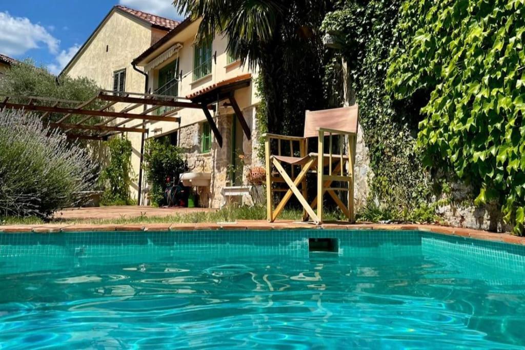een zwembad met een stoel voor een huis bij Casa di Pepi, Kras Carso 