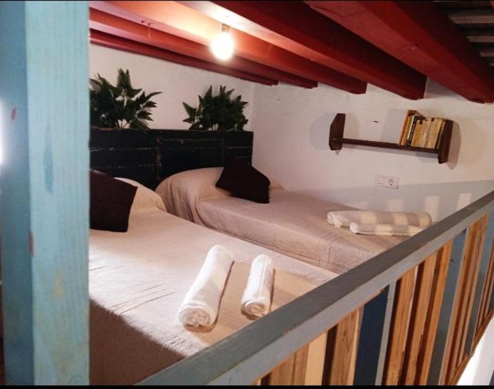 een kamer met twee bedden met witte sokken erop bij Casa Nayib in Vejer de la Frontera
