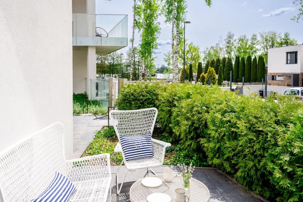 a patio with two chairs and a table at Apartament Olimpijska z ogródkiem i widokiem na jezioro in Olsztyn