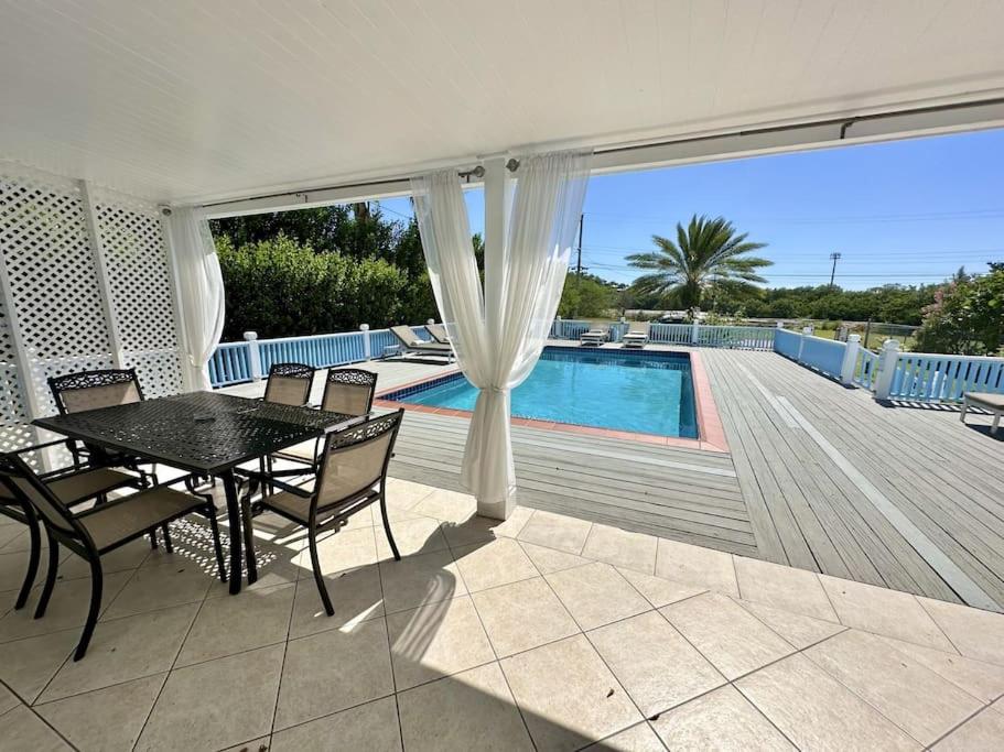 a patio with a table and chairs next to a pool at Villa Utopia in Jolly Harbour