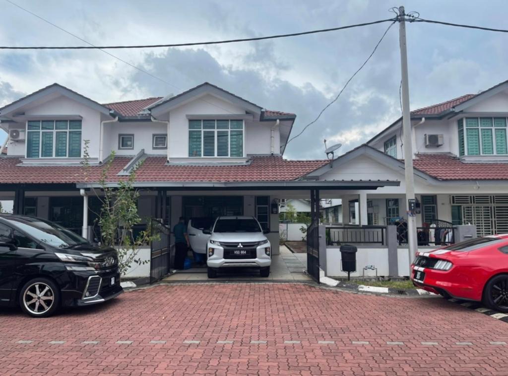uma casa com carros estacionados em frente em NO 5 NAZIRIN HOMESTAY Tmn Desa Manjung em Lumut