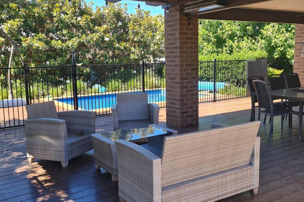 a patio with chairs and a table and a pool at Sojourn on Stewart - Mansfield House with Spa Bath in Mansfield