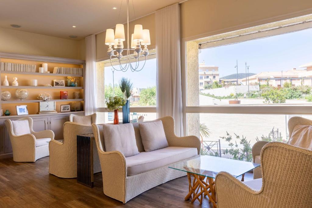 a living room with a couch and chairs and a large window at Best Western Hotel Matisse in Sainte-Maxime