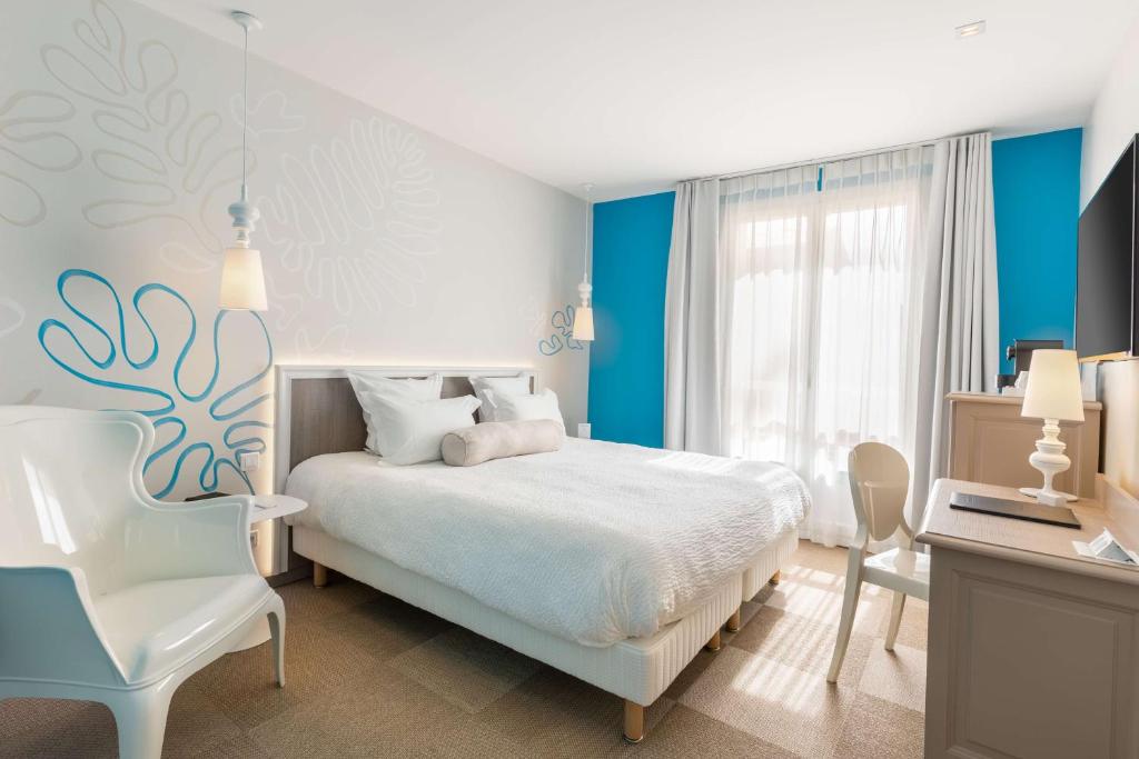 a bedroom with a bed and a desk and a chair at Best Western Hotel Matisse in Sainte-Maxime