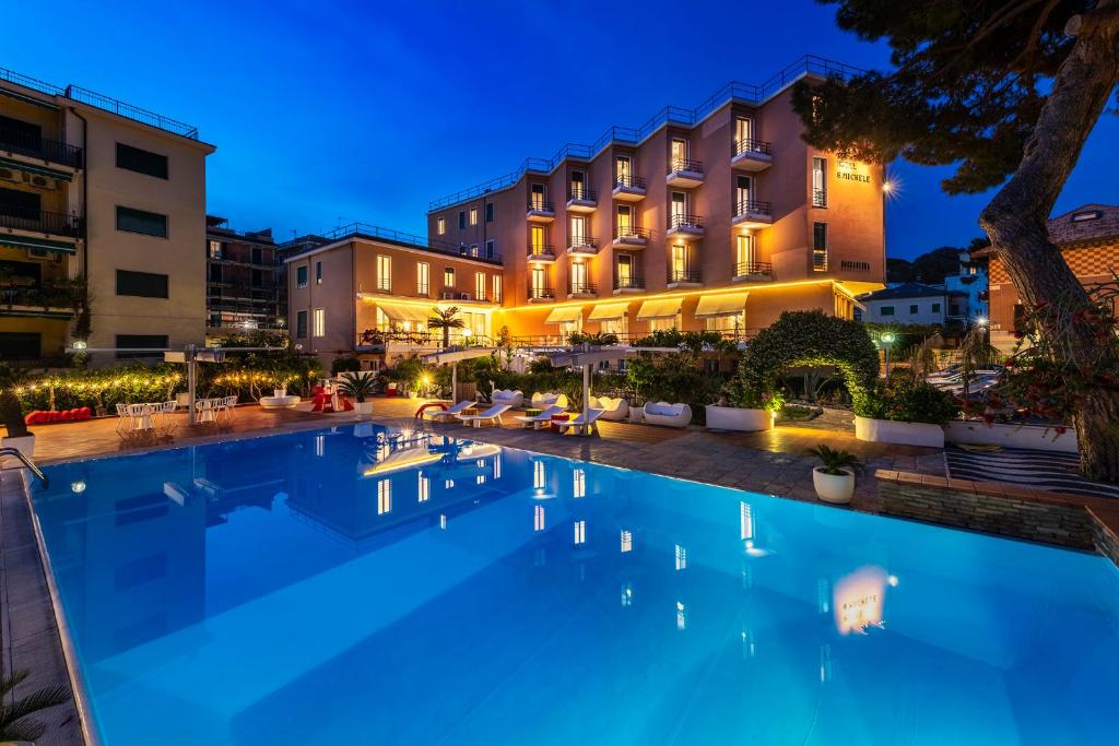 a large swimming pool in front of a building at Hotel San Michele in Celle Ligure