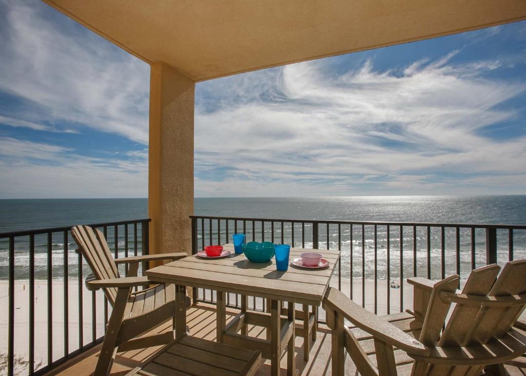 een tafel en stoelen op een balkon met uitzicht op de oceaan bij Phoenix V 1404 in Orange Beach