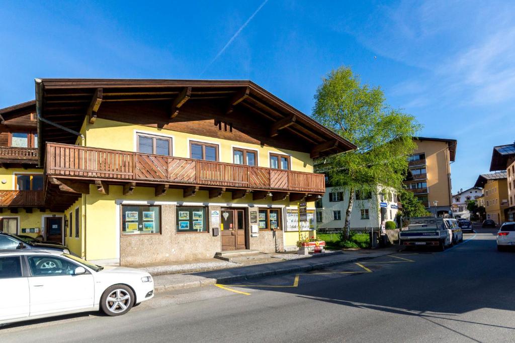a building with a balcony on the side of a street at Ski-n-Lake City Apartments in Zell am See