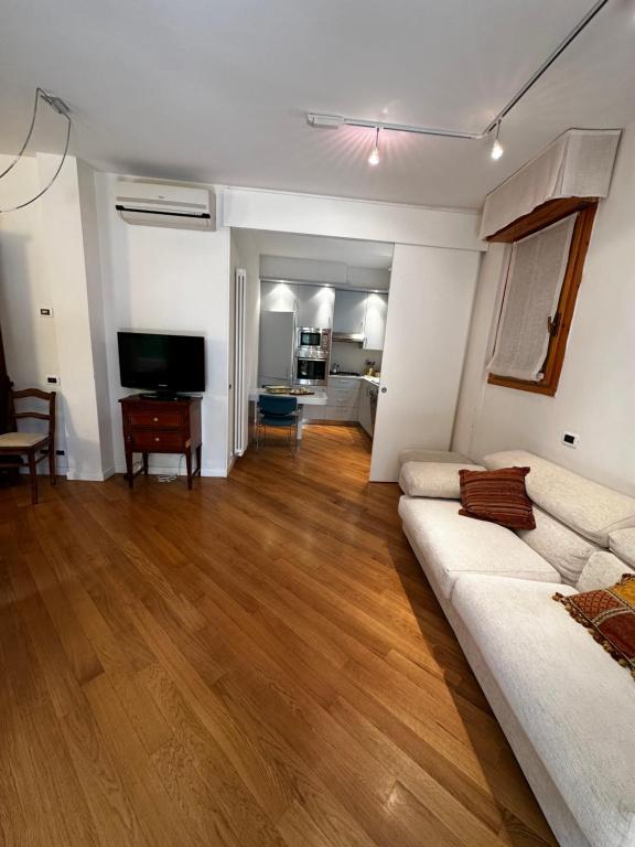 sala de estar con sofá blanco y suelo de madera en Villa AnRo en Vidiciatico