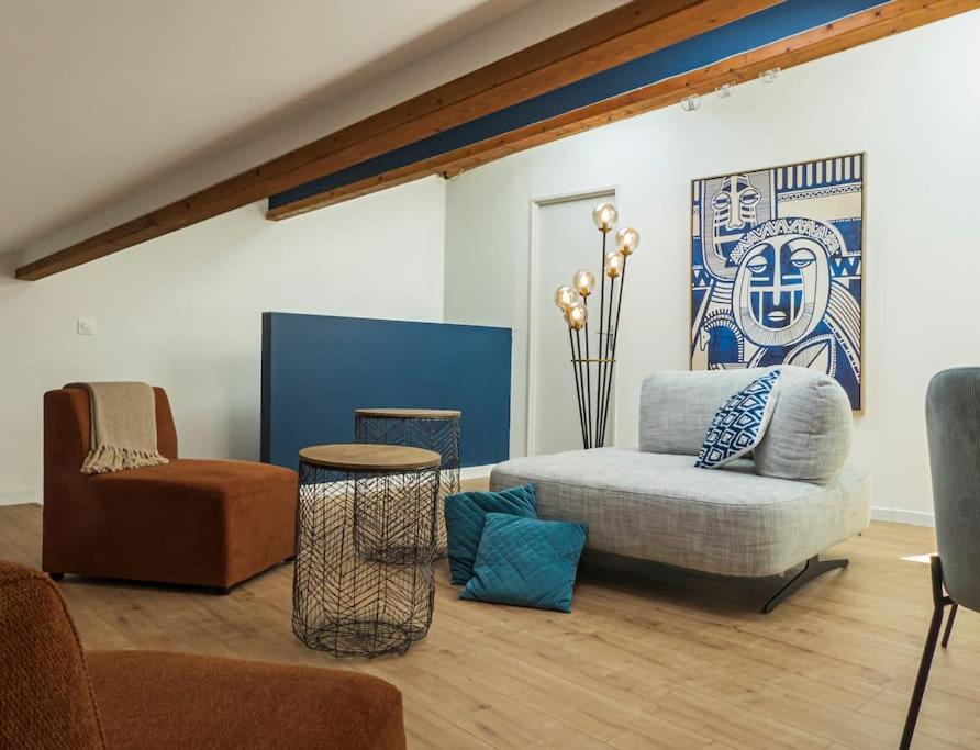 salon z kanapą i krzesłem w obiekcie Les Rives Bleues - atypique et climatisé - 2 salles d'eau - Wifi w mieście Albi