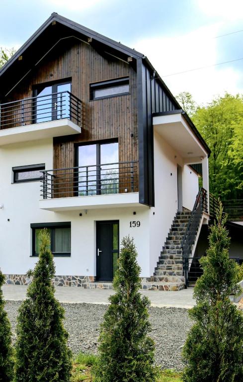a house with a black roof at Cabana Armonia in Baia-Sprie