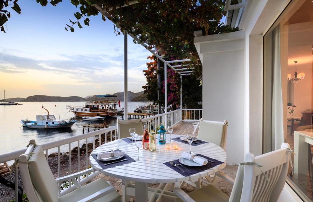 una mesa en un balcón con vistas al agua en Villa Ruyam en Marmaris