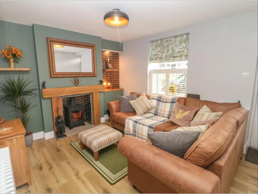a living room with two couches and a fireplace at Sunshine Cottage Tideswell, Games room included. in Tideswell