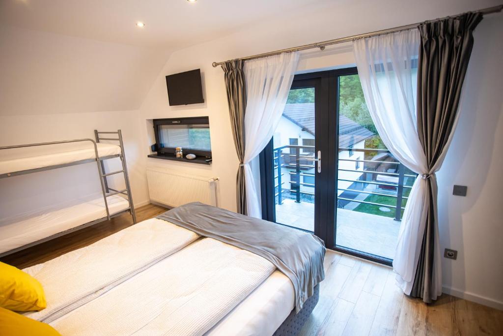 sypialnia z łóżkiem i przesuwnymi szklanymi drzwiami w obiekcie Cabana Armonia w mieście Baia Sprie