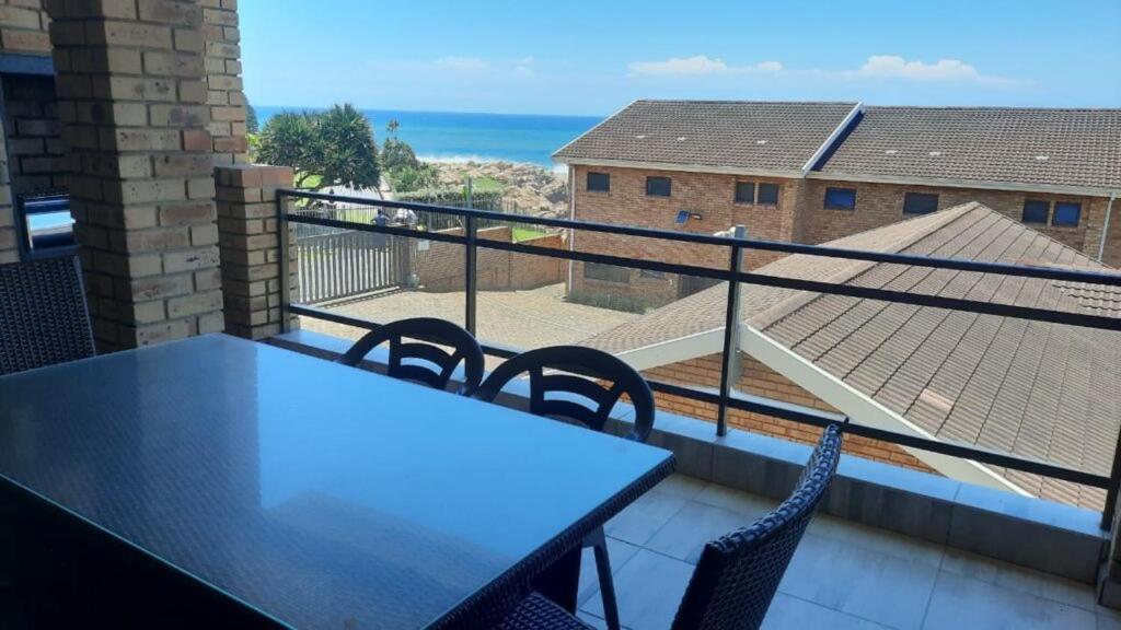 a balcony with a table and chairs and the ocean at Villa Siesta Flat No.6 in Margate
