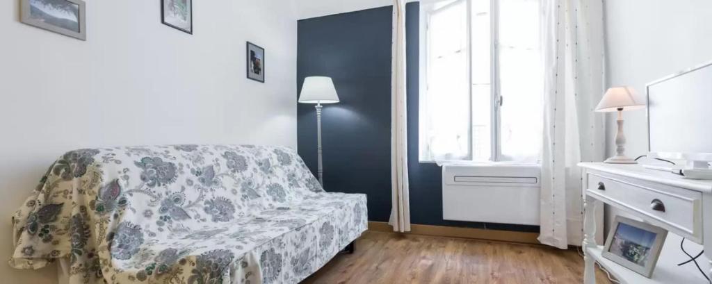 a small bedroom with a bed and a window at Le Fersen - cosy studio- coeur vieil Antibes in Antibes