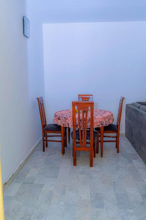 einen Esstisch mit 2 Stühlen, einem Tisch und einem Sofa in der Unterkunft Au cœur de Bonanjo in Douala